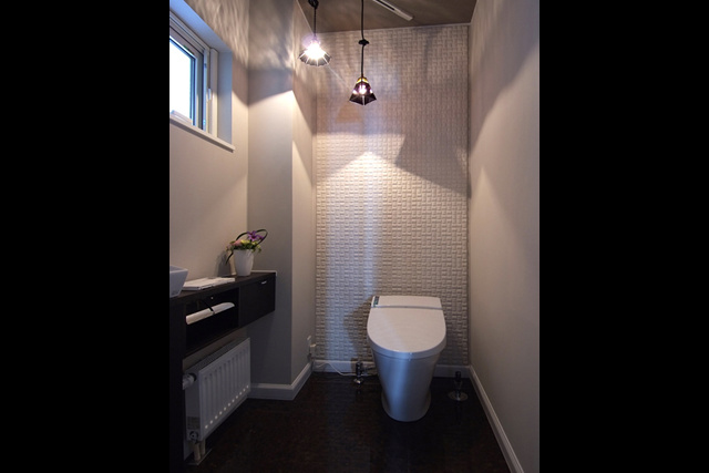 トイレ： エコカラットタイルの凹凸と ランプシェードの影が美しい。